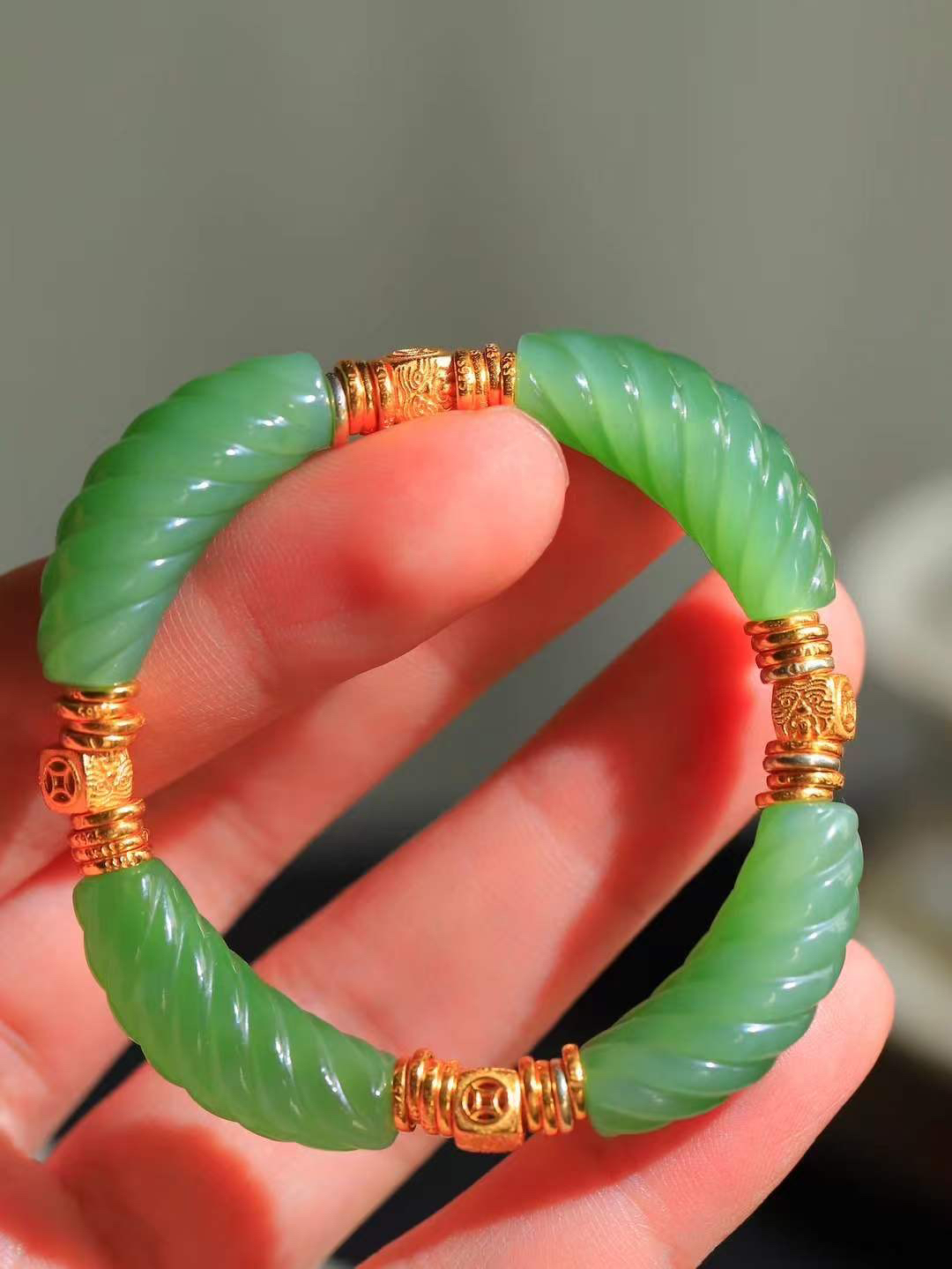 【绞丝纹.手串】

精品和田玉碧玉绞丝纹手串，以清润碧玉雕琢绞丝纹理，如碧丝萦回，寓意生机盎然、福运绵延；搭配古法金饰，铜钱纹藏招财进宝之意，吉祥纹纳平安顺遂之福。碧玉凝翠，金辉熠熠，既显东方清雅风骨，又藏富贵安康祈愿，是自戴祈福、赠友传情的雅致之选。重27.3克  尺寸取一30.2-9-10.2mm 89351200T