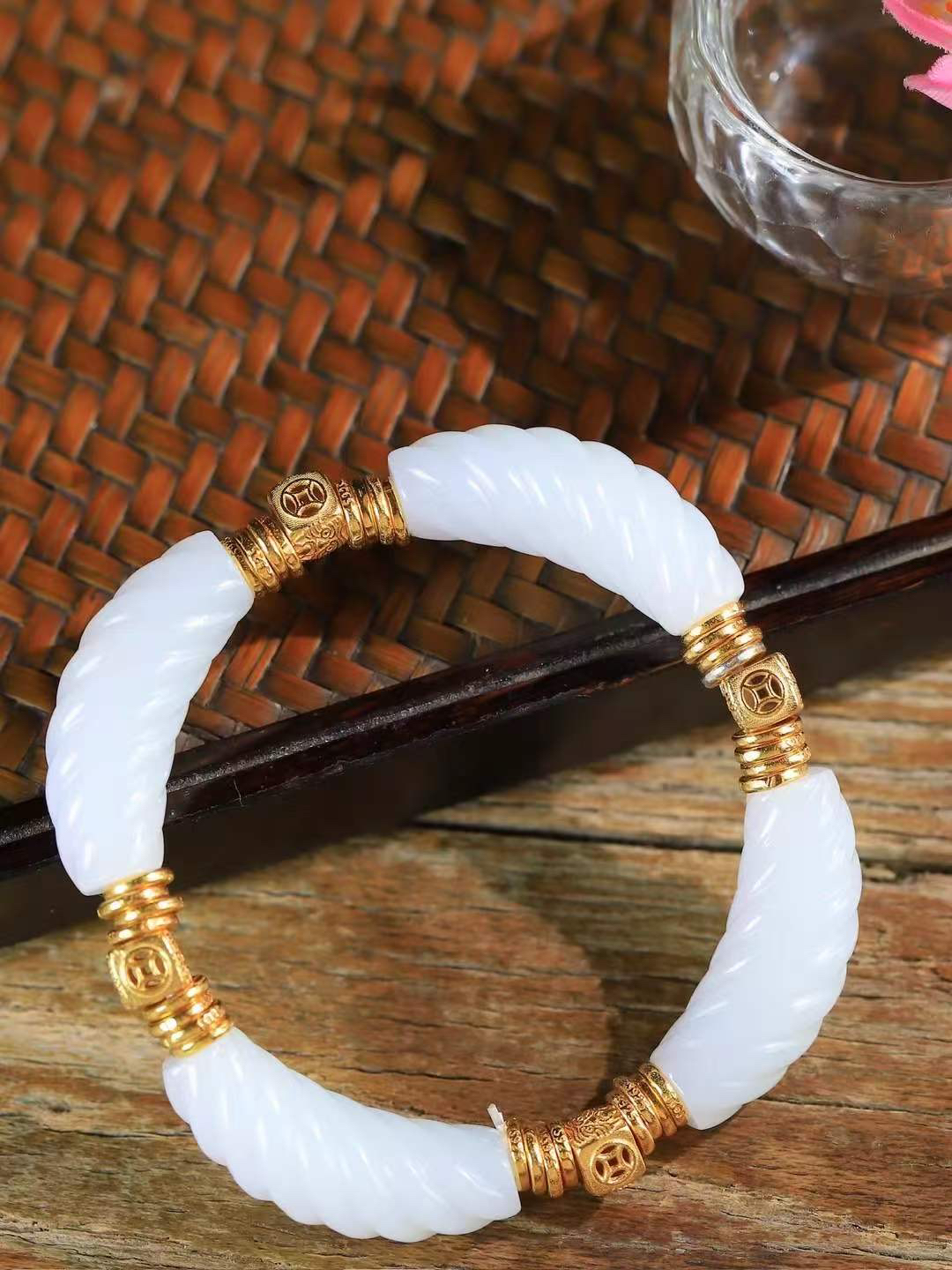 【925银.绞丝纹.手串】

精品和田玉白玉绞丝纹手串，手串以温润白玉雕琢绞丝纹理，如丝绦缠绕，寓意情意绵长、福寿永续；搭配古法金饰，铜钱纹藏财源滚滚之意，吉祥纹纳平安顺遂之福。白玉凝洁，金辉璀璨，既显东方雅致风骨，又藏富贵安康祈愿，是自戴祈福、赠友传情的上佳之选。重27.2克  尺寸取一30-10.2-10.2mm 99301200T