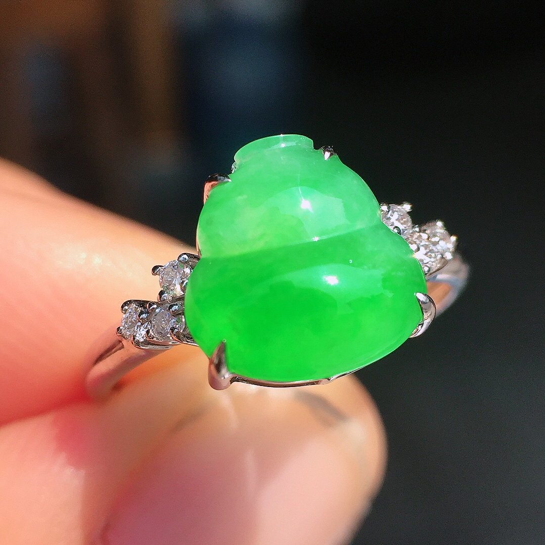 阳绿葫芦戒指，色泽均匀艳丽，玉质细腻，荧光感超
强，饱满圆润，尽显优雅气质，18k
金豪华镶嵌