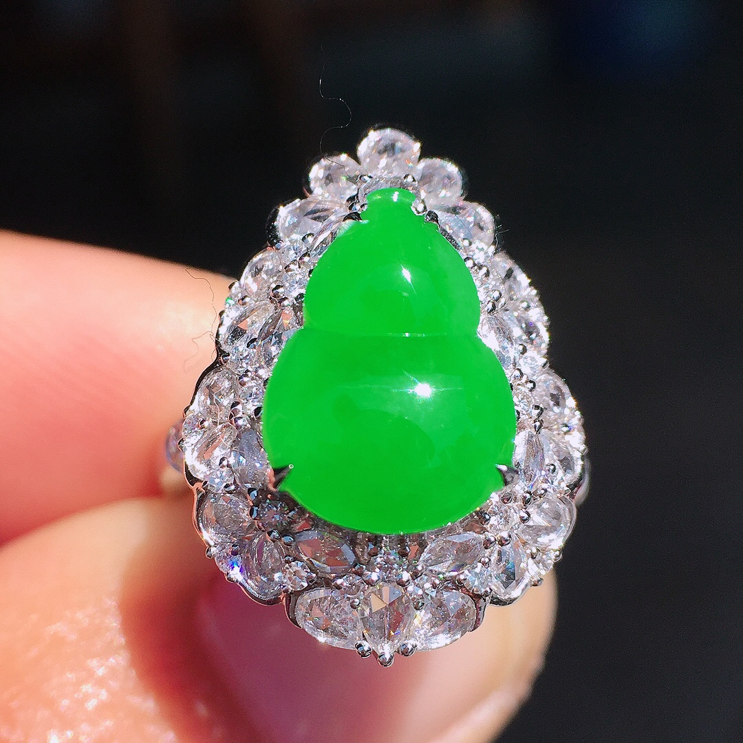 正阳绿葫芦戒指，色泽均匀艳丽，玉质细腻，荧光感超
强，饱满圆润，尽显优雅气质，18k
金豪华镶嵌