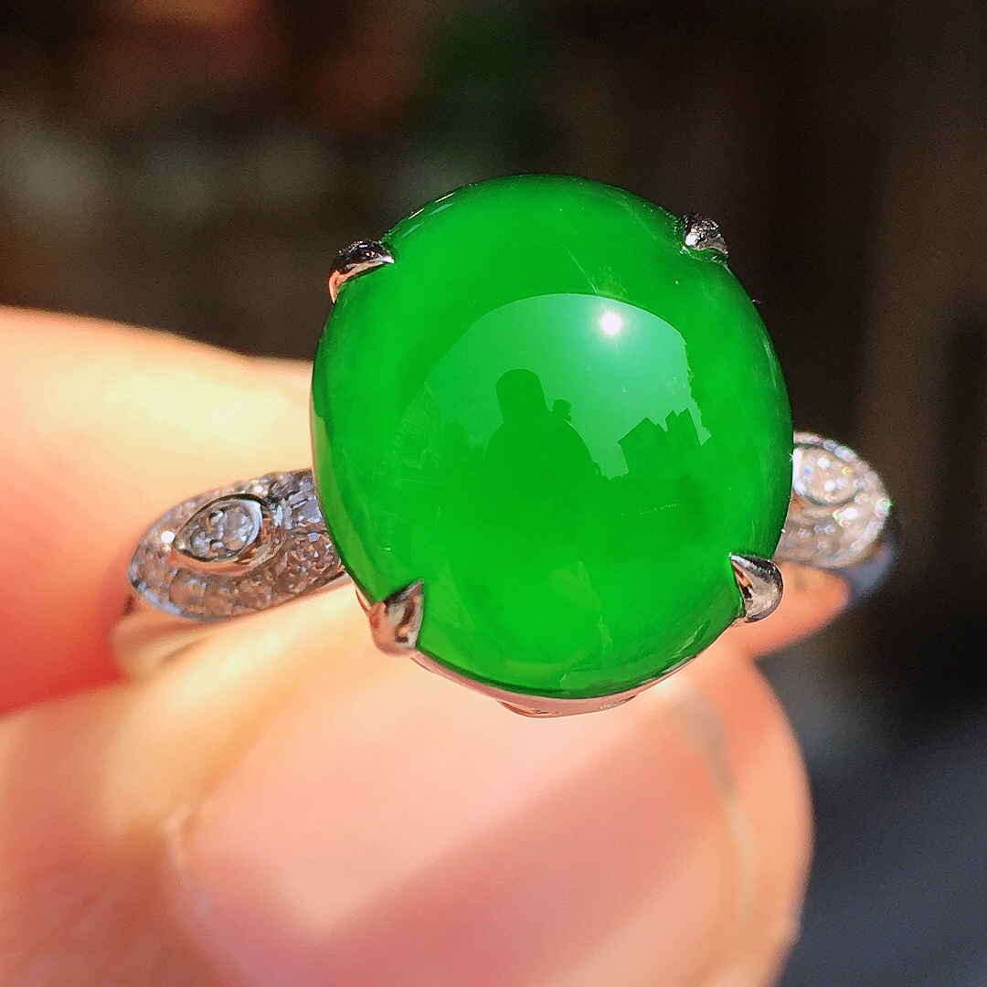 阳绿蛋面戒指，色泽均匀艳丽，玉质细腻，荧光感超
强，饱满圆润，尽显优雅气质，18k
金豪华镶嵌