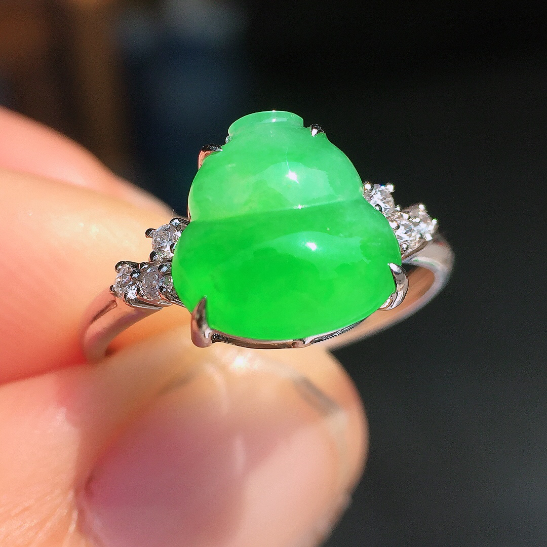 阳绿葫芦戒指，色泽均匀艳丽，玉质细腻，荧光感超
强，饱满圆润，尽显优雅气质，18k
金豪华镶嵌