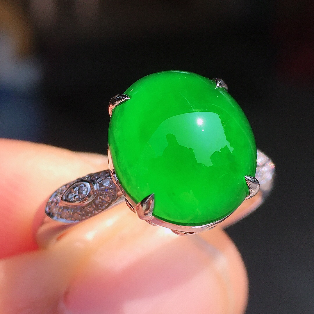 阳绿蛋面戒指，色泽均匀艳丽，玉质细腻，荧光感超
强，饱满圆润，尽显优雅气质，18k
金豪华镶嵌