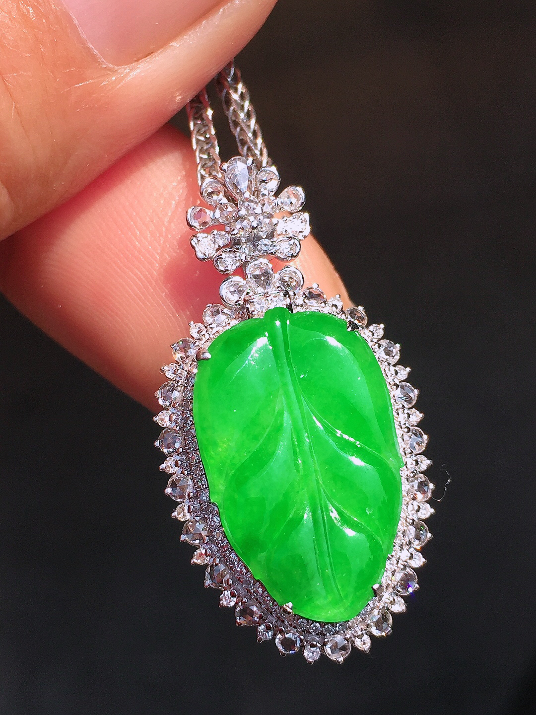 阳绿玉叶吊坠，色泽均匀艳丽，玉质细腻，荧光感超
强，饱满圆润，尽显优雅气质，18k
金豪华镶嵌