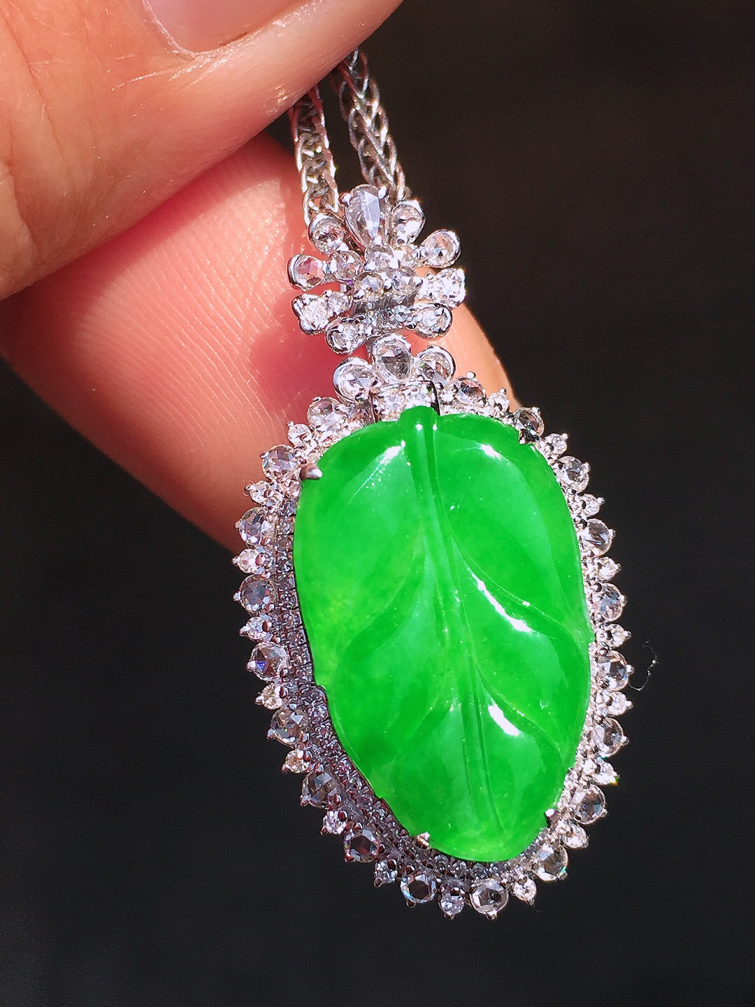 阳绿玉叶吊坠，色泽均匀艳丽，玉质细腻，荧光感超
强，饱满圆润，尽显优雅气质，18k
金豪华镶嵌