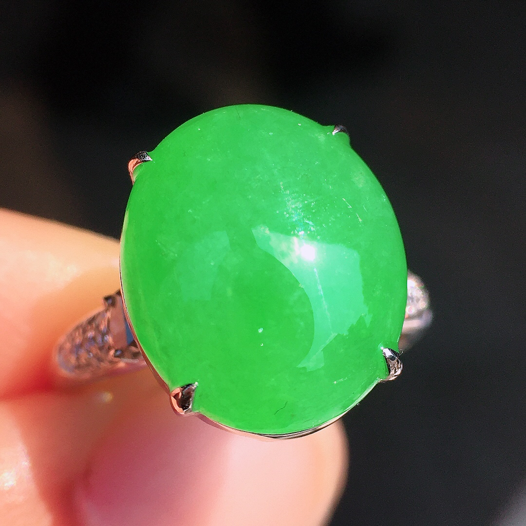 阳绿蛋面戒指，色泽均匀艳丽，玉质细腻，荧光感超
强，饱满圆润，尽显优雅气质，18k
金豪华镶嵌