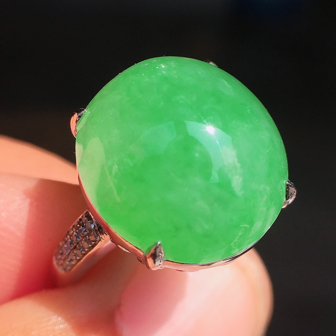 阳绿蛋面戒指，色泽均匀艳丽，玉质细腻，荧光感超
强，饱满圆润，尽显优雅气质，18k
金豪华镶嵌