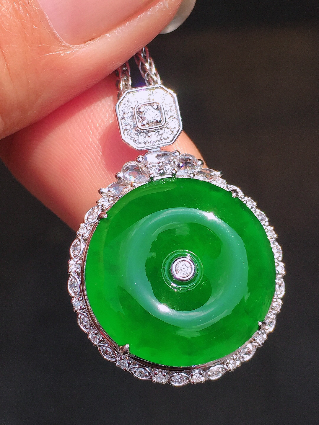 满绿平安扣吊坠，色泽均匀艳丽，玉质细腻，荧光感超
强，饱满圆润，尽显优雅气质，18k
金豪华镶嵌