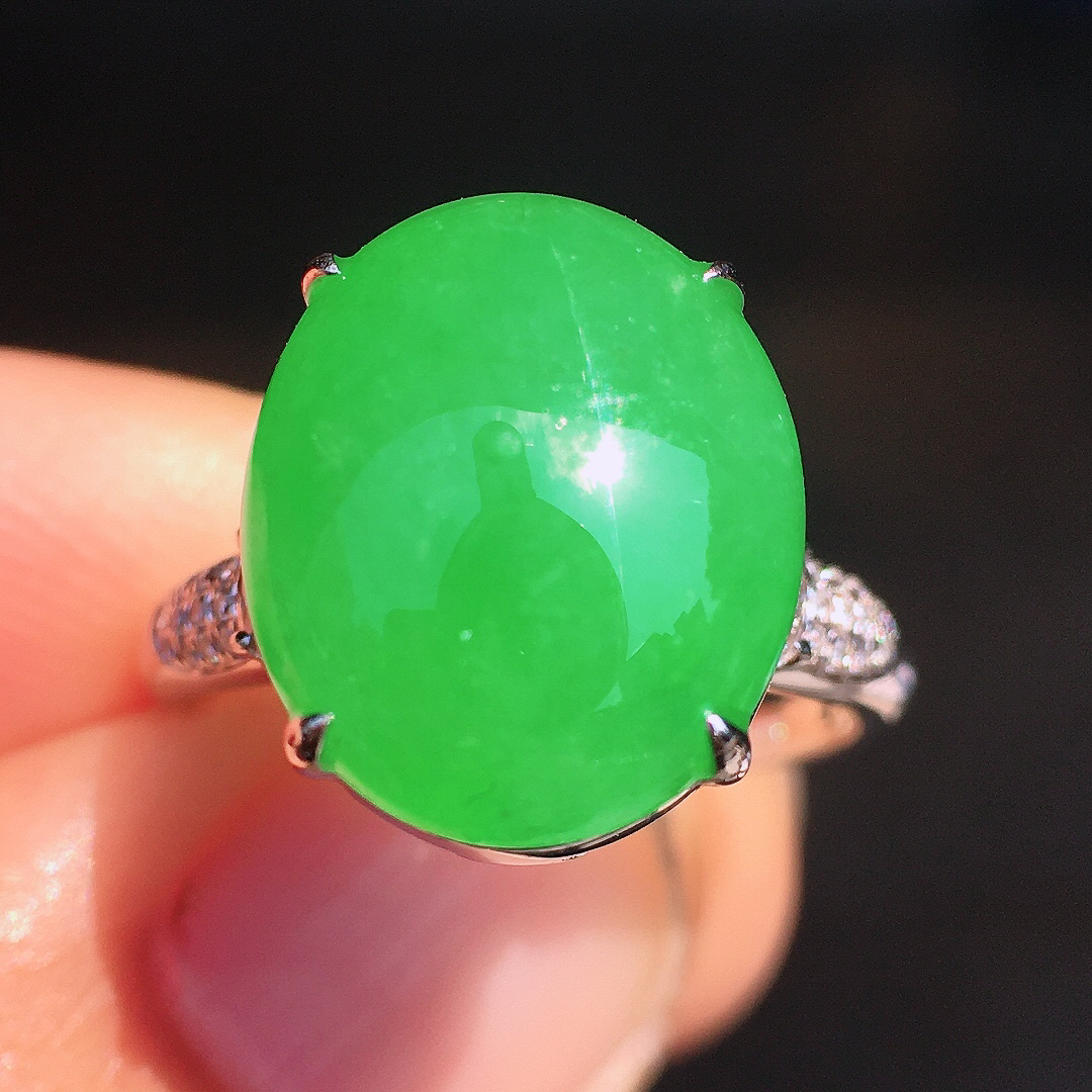 阳绿蛋面戒指，色泽均匀艳丽，玉质细腻，荧光感超
强，饱满圆润，尽显优雅气质，18k
金豪华镶嵌