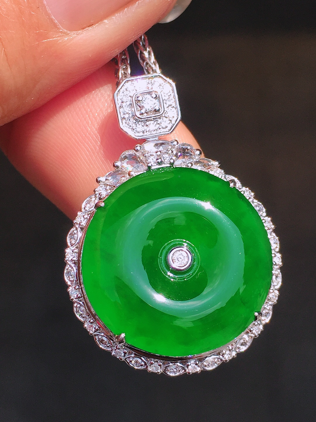 满绿平安扣吊坠，色泽均匀艳丽，玉质细腻，荧光感超
强，饱满圆润，尽显优雅气质，18k
金豪华镶嵌