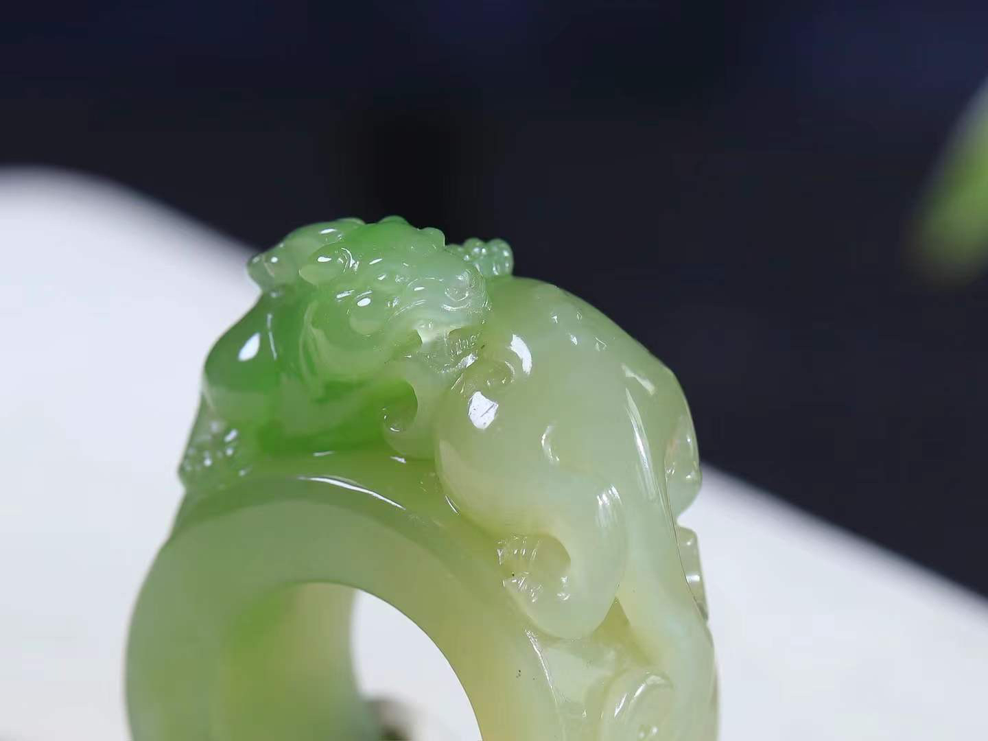 【招财貔貅.扳指]

精品和田玉翠青貔貅扳指、手把件质地油润，手感上佳。精工雕刻，貔貅表情生猛威严，形象立体生动，有纳食四方之财，消灾好运的寓意，貔貅属火，火主心，心主神明，祈福佩戴者聪慧灵秀。内径22mn尺寸18.2-23mm，重54克fDL-10301500