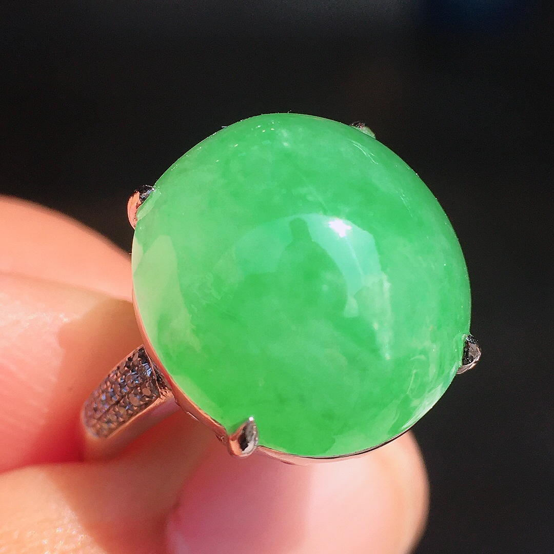 阳绿蛋面戒指，色泽均匀艳丽，玉质细腻，荧光感超
强，饱满圆润，尽显优雅气质，18k
金豪华镶嵌