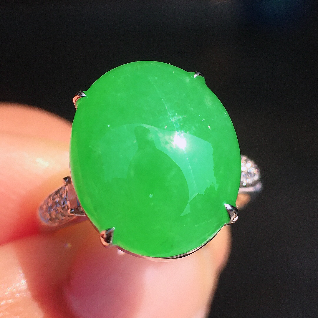 阳绿蛋面戒指，色泽均匀艳丽，玉质细腻，荧光感超
强，饱满圆润，尽显优雅气质，18k
金豪华镶嵌