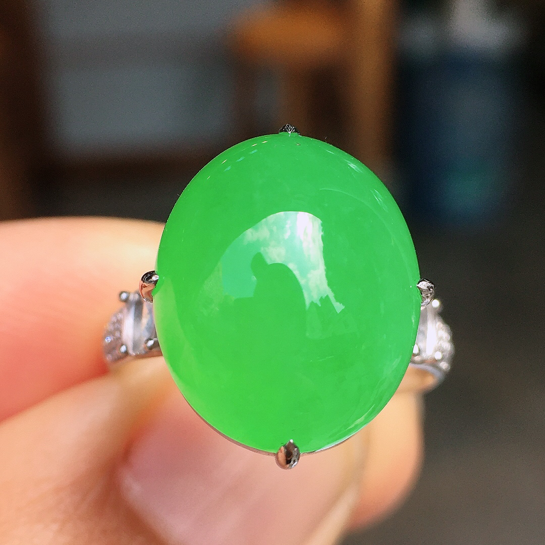 阳绿蛋面戒指，色泽均匀艳丽，玉质细腻，荧光感超
强，饱满圆润，尽显优雅气质，18k
金豪华镶嵌