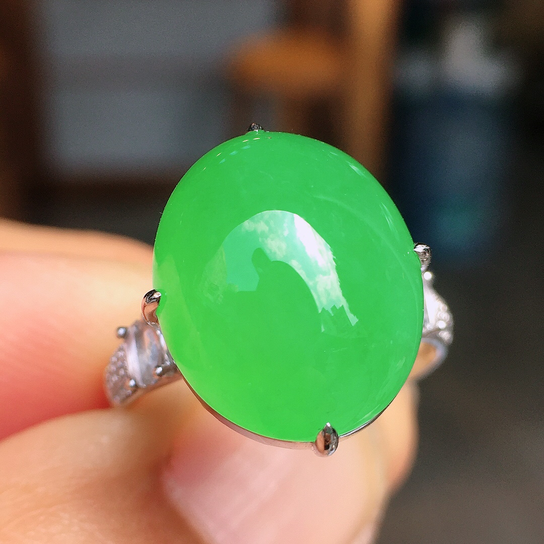 阳绿蛋面戒指，色泽均匀艳丽，玉质细腻，荧光感超
强，饱满圆润，尽显优雅气质，18k
金豪华镶嵌