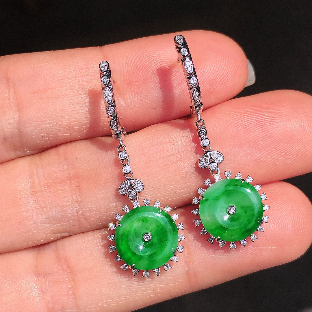 阳绿平安扣耳坠，色泽均匀艳丽，玉质细腻，荧光感超
强，饱满圆润，尽显优雅气质，18k
金豪华镶嵌