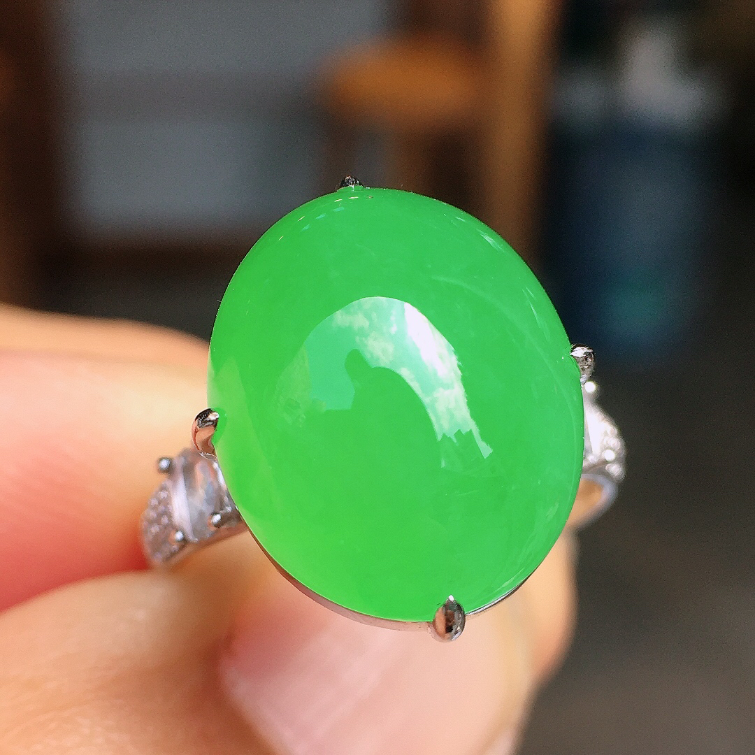 阳绿蛋面戒指，色泽均匀艳丽，玉质细腻，荧光感超
强，饱满圆润，尽显优雅气质，18k
金豪华镶嵌