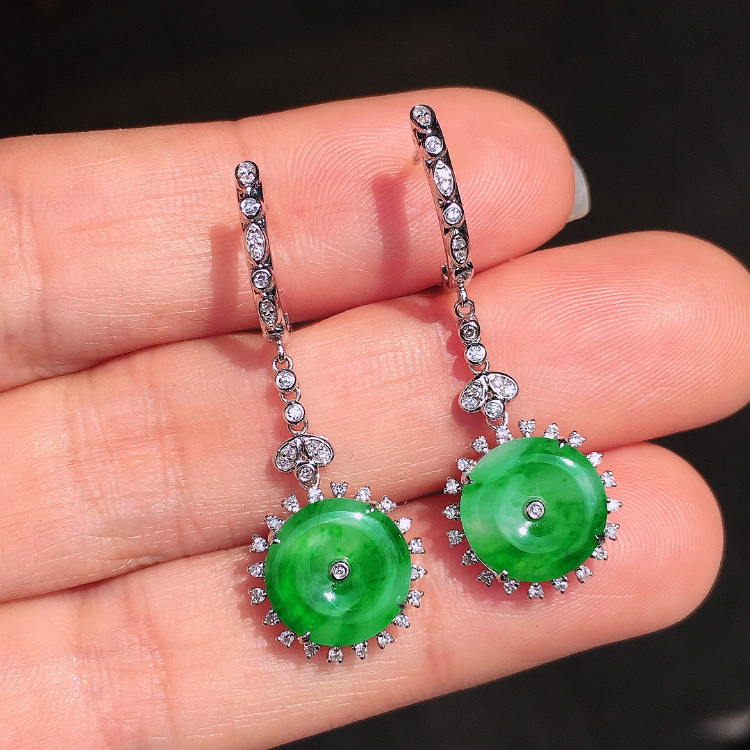阳绿平安扣耳坠，色泽均匀艳丽，玉质细腻，荧光感超
强，饱满圆润，尽显优雅气质，18k
金豪华镶嵌