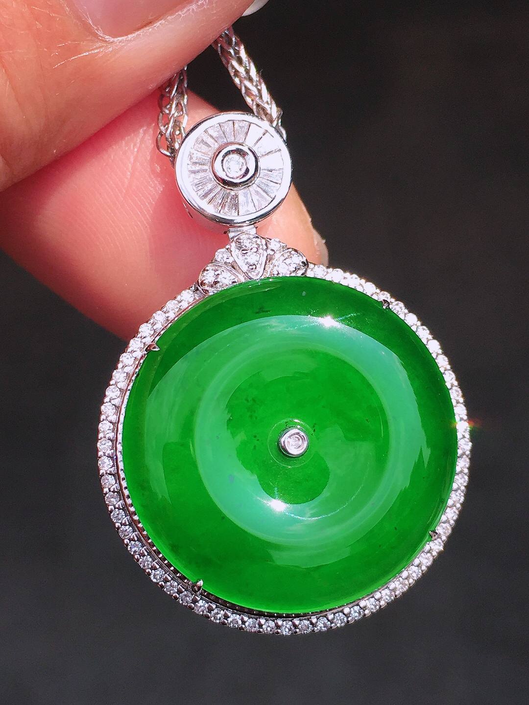 阳绿平安扣吊坠，色泽均匀艳丽，玉质细腻，荧光感超
强，饱满圆润，尽显优雅气质，18k
金豪华镶嵌