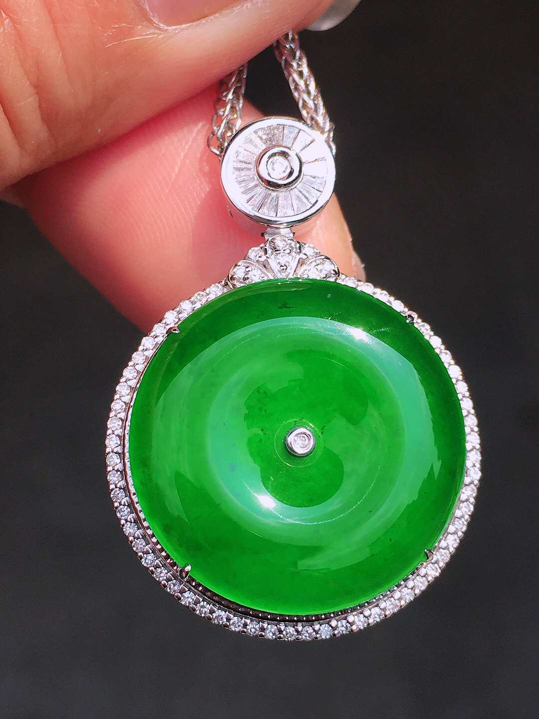 阳绿平安扣吊坠，色泽均匀艳丽，玉质细腻，荧光感超
强，饱满圆润，尽显优雅气质，18k
金豪华镶嵌