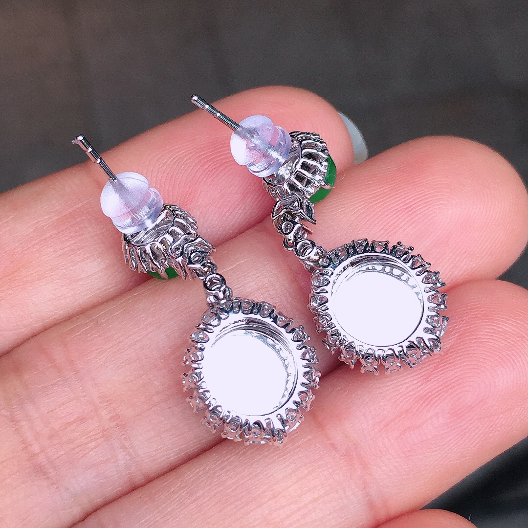 阳绿平安扣耳坠，色泽均匀艳丽，玉质细腻，荧光感超
强，饱满圆润，尽显优雅气质，18k
金豪华镶嵌