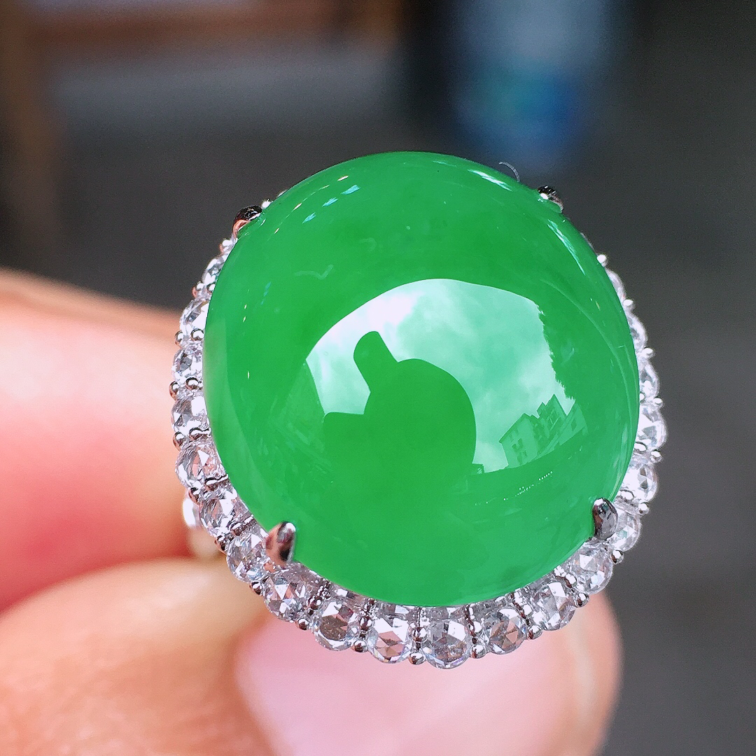 阳绿蛋面戒指，色泽均匀艳丽，玉质细腻，荧光感超
强，饱满圆润，尽显优雅气质，18k
金豪华镶嵌