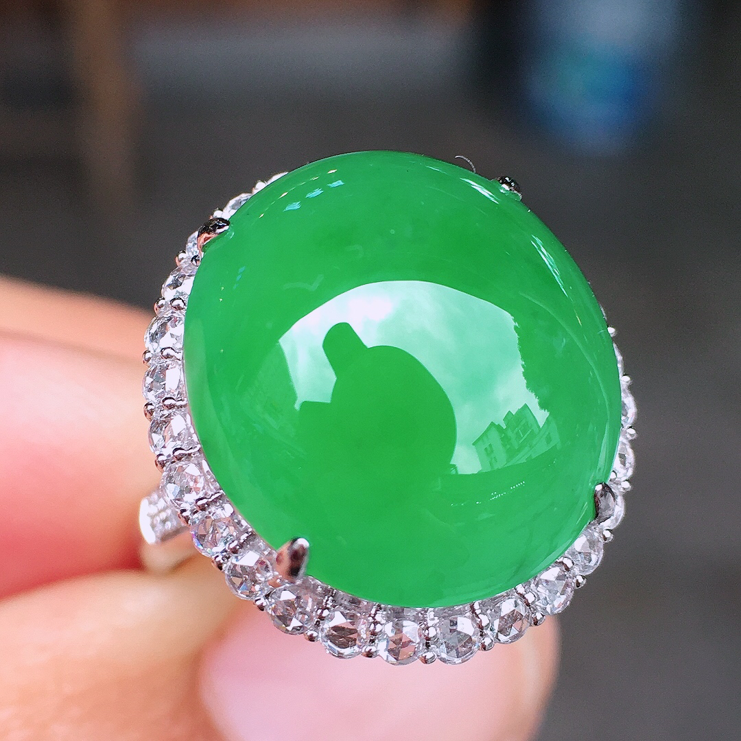 阳绿蛋面戒指，色泽均匀艳丽，玉质细腻，荧光感超
强，饱满圆润，尽显优雅气质，18k
金豪华镶嵌