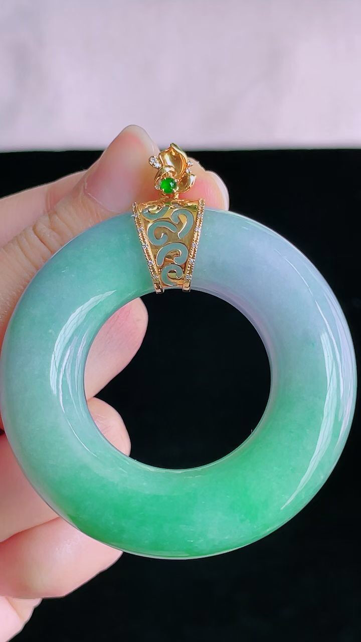 【翡翠名称】18K金镶冰春彩大平安环挂件
【翡翠尺寸】直径厚度裸石55.2/12.4mm
【翡翠描述