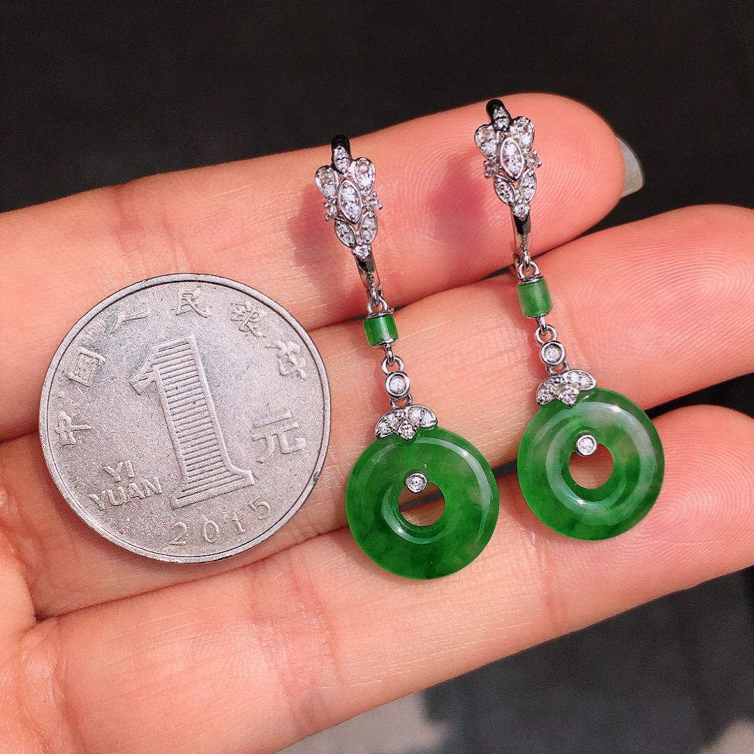 阳绿平安扣耳坠，色泽均匀艳丽，玉质细腻，荧光感超
强，饱满圆润，尽显优雅气质，18k
金豪华镶嵌