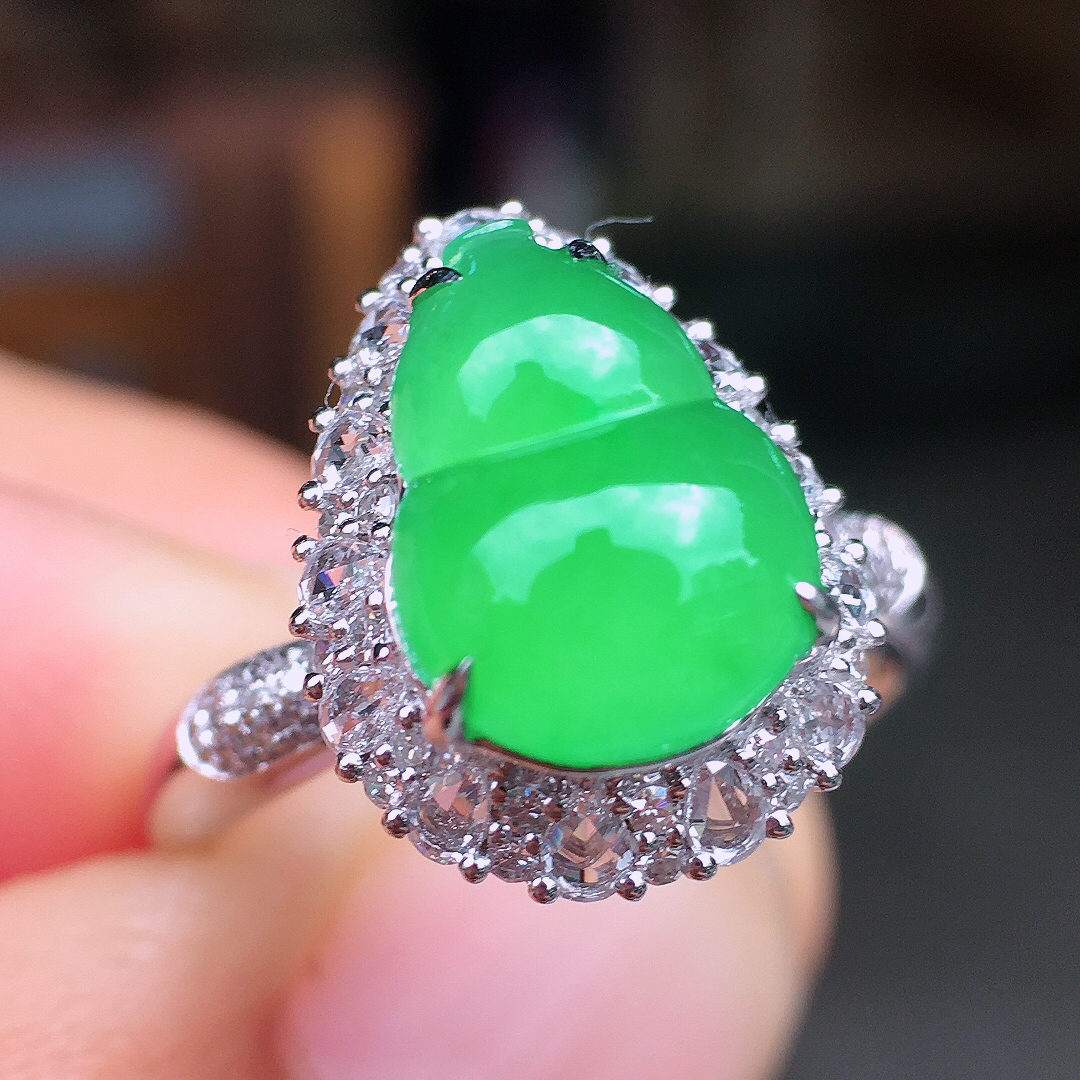 阳绿葫芦戒指，色泽均匀艳丽，玉质细腻，荧光感超
强，饱满圆润，尽显优雅气质，18k
金豪华镶嵌