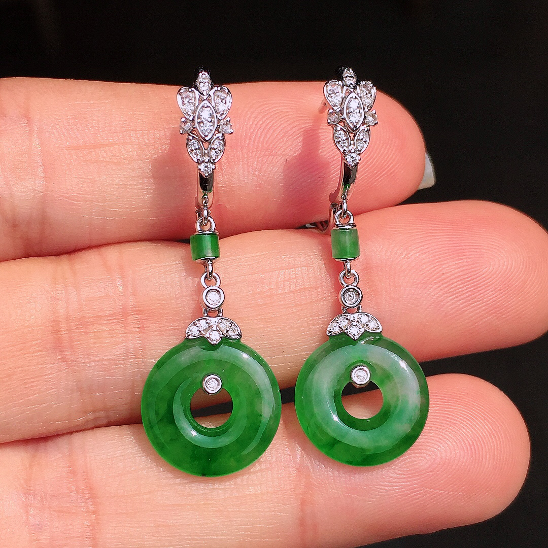 阳绿平安扣耳坠，色泽均匀艳丽，玉质细腻，荧光感超
强，饱满圆润，尽显优雅气质，18k
金豪华镶嵌