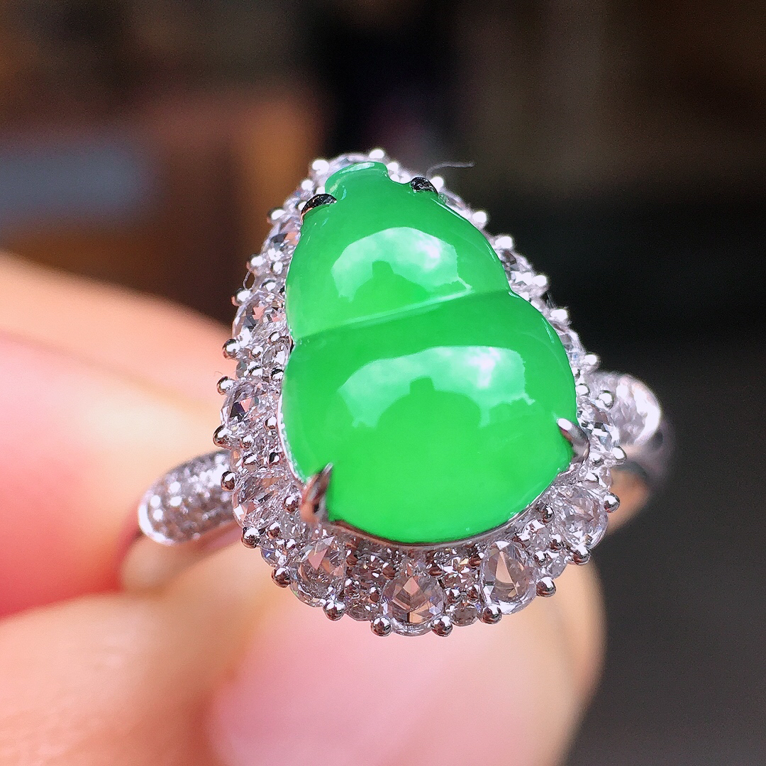 阳绿葫芦戒指，色泽均匀艳丽，玉质细腻，荧光感超
强，饱满圆润，尽显优雅气质，18k
金豪华镶嵌