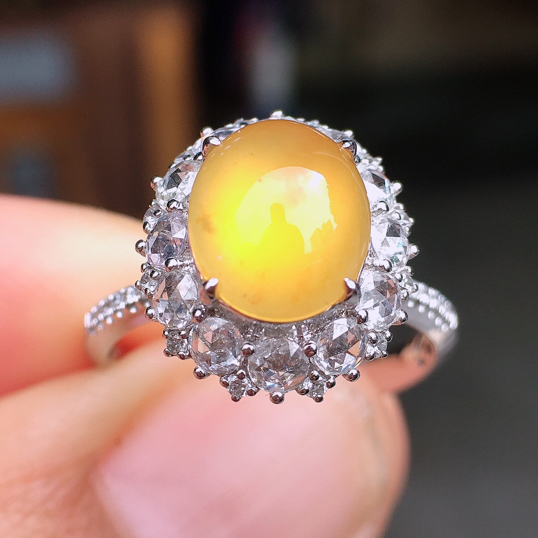 黄翡蛋面戒指，色泽均匀艳丽，玉质细腻，荧光感超
强，饱满圆润，尽显优雅气质，18k
金豪华镶嵌