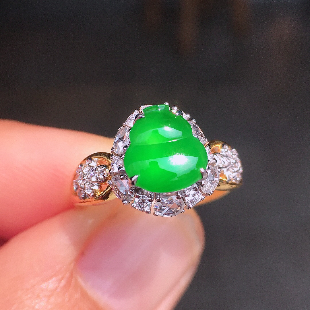 阳绿葫芦戒指，色泽均匀艳丽，玉质细腻，荧光感超
强，饱满圆润，尽显优雅气质，18k
金豪华镶嵌