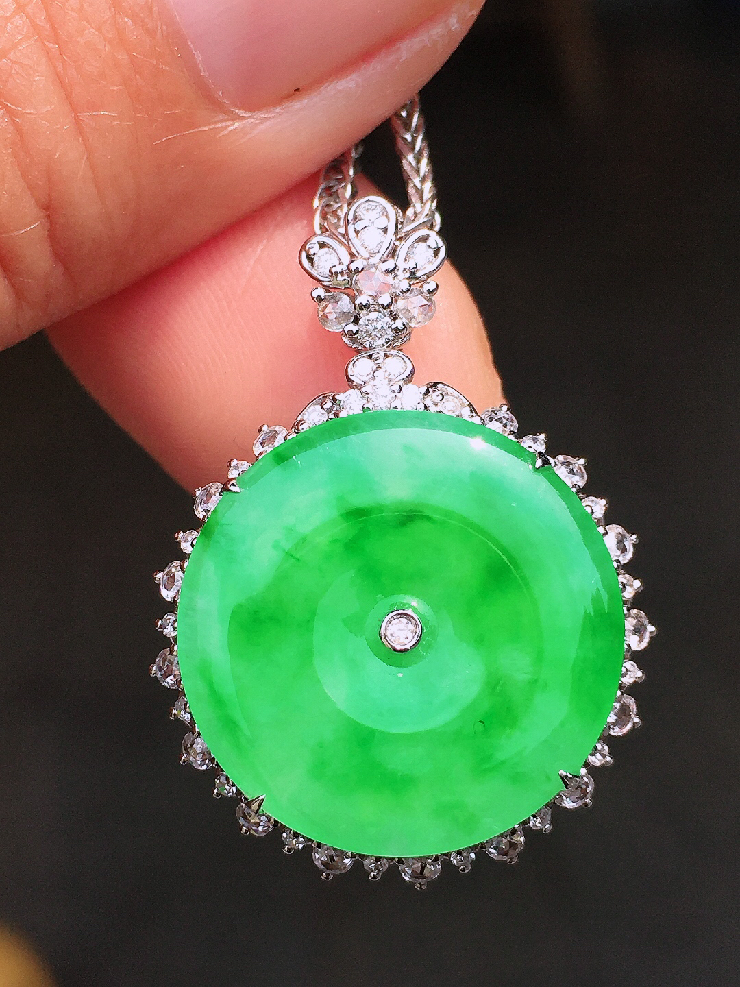 阳绿平安扣吊坠，色泽均匀艳丽，玉质细腻，荧光感超
强，饱满圆润，尽显优雅气质，18k
金豪华镶嵌