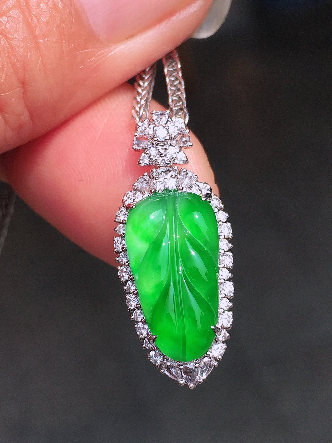 阳绿玉叶吊坠，色泽均匀艳丽，玉质细腻，荧光感超
强，饱满圆润，尽显优雅气质，18k
金豪华镶嵌