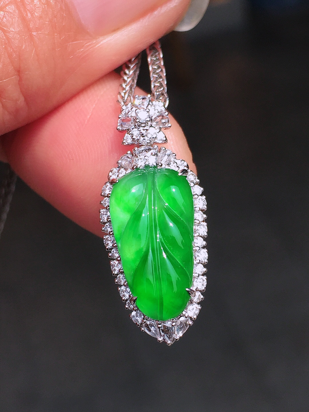 阳绿玉叶吊坠，色泽均匀艳丽，玉质细腻，荧光感超
强，饱满圆润，尽显优雅气质，18k
金豪华镶嵌