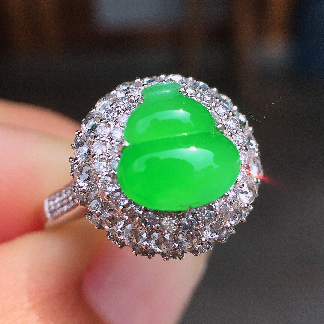 阳绿葫芦戒指，色泽均匀艳丽，玉质细腻，荧光感超
强，饱满圆润，尽显优雅气质，18k
金豪华镶嵌