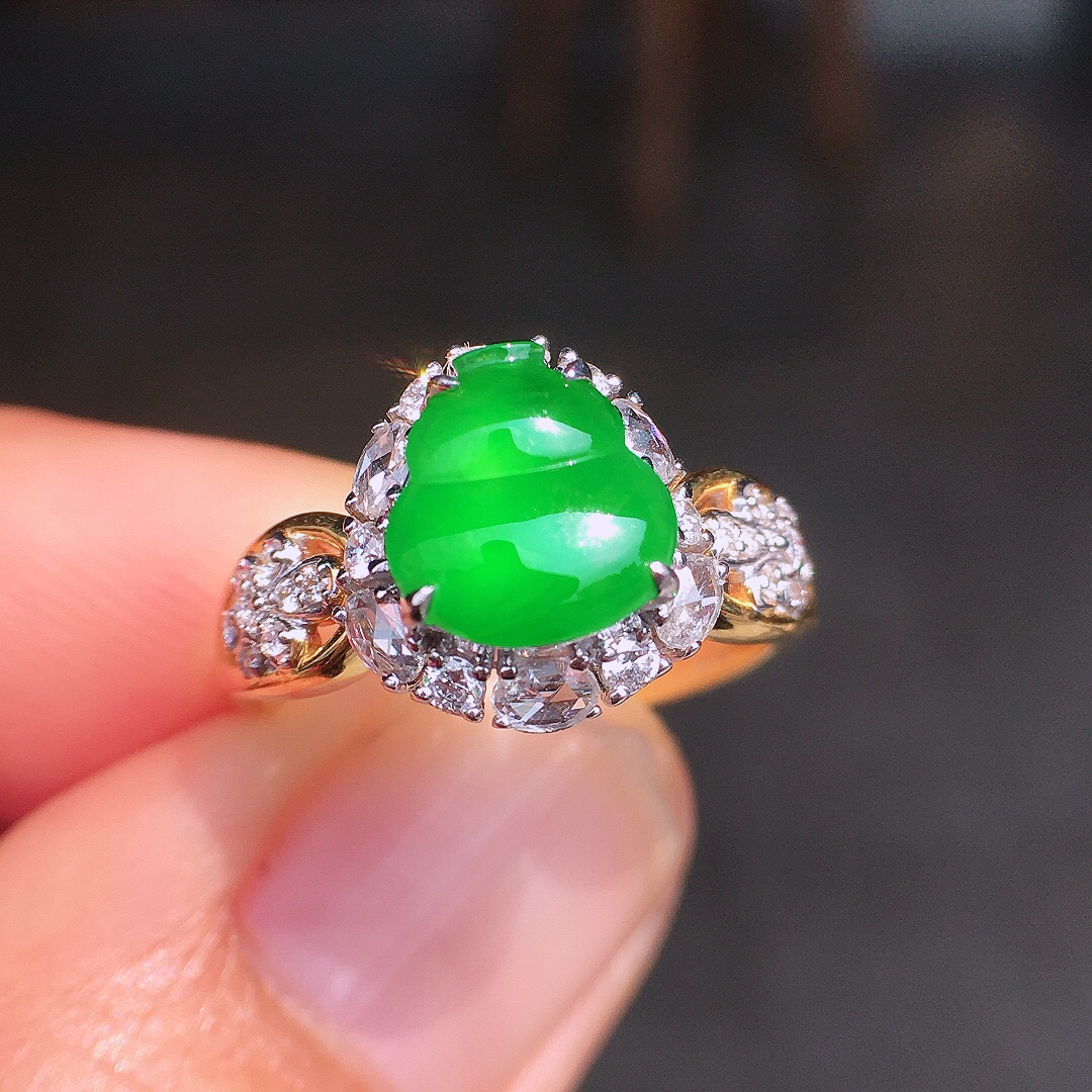 阳绿葫芦戒指，色泽均匀艳丽，玉质细腻，荧光感超
强，饱满圆润，尽显优雅气质，18k
金豪华镶嵌