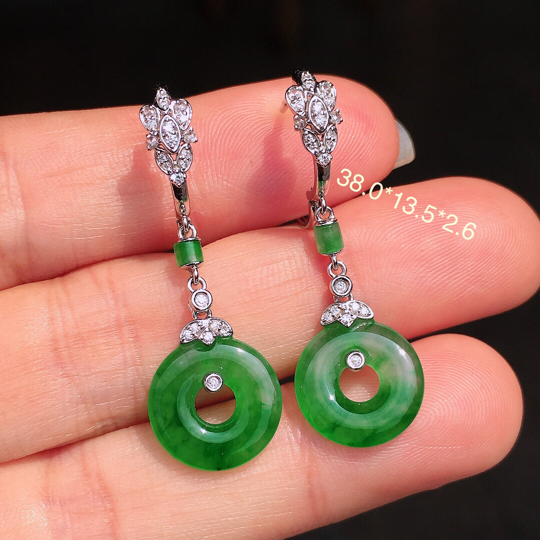 阳绿平安扣耳坠，色泽均匀艳丽，玉质细腻，荧光感超
强，饱满圆润，尽显优雅气质，18k
金豪华镶嵌