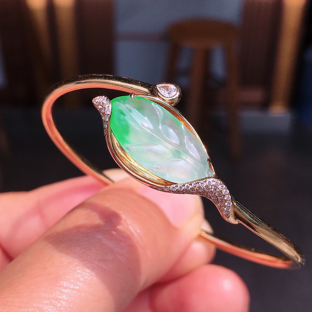 飘绿玉叶手环，色泽艳丽，玉质细腻，荧光感超
强，饱满圆润，尽显优雅气质，18k
金豪华镶嵌