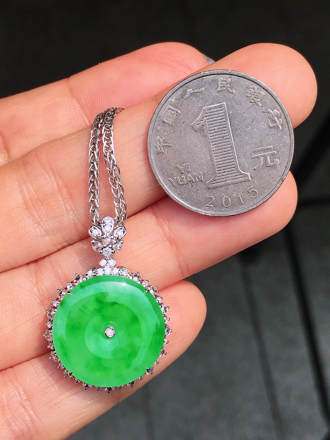 阳绿平安扣吊坠，色泽均匀艳丽，玉质细腻，荧光感超
强，饱满圆润，尽显优雅气质，18k
金豪华镶嵌