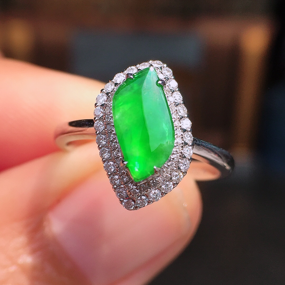 阳绿随形戒指，色泽均匀艳丽，玉质细腻，荧光感超
强，饱满圆润，尽显优雅气质，18k
金豪华镶嵌