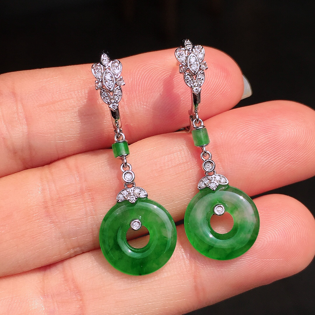 阳绿平安扣耳坠，色泽均匀艳丽，玉质细腻，荧光感超
强，饱满圆润，尽显优雅气质，18k
金豪华镶嵌