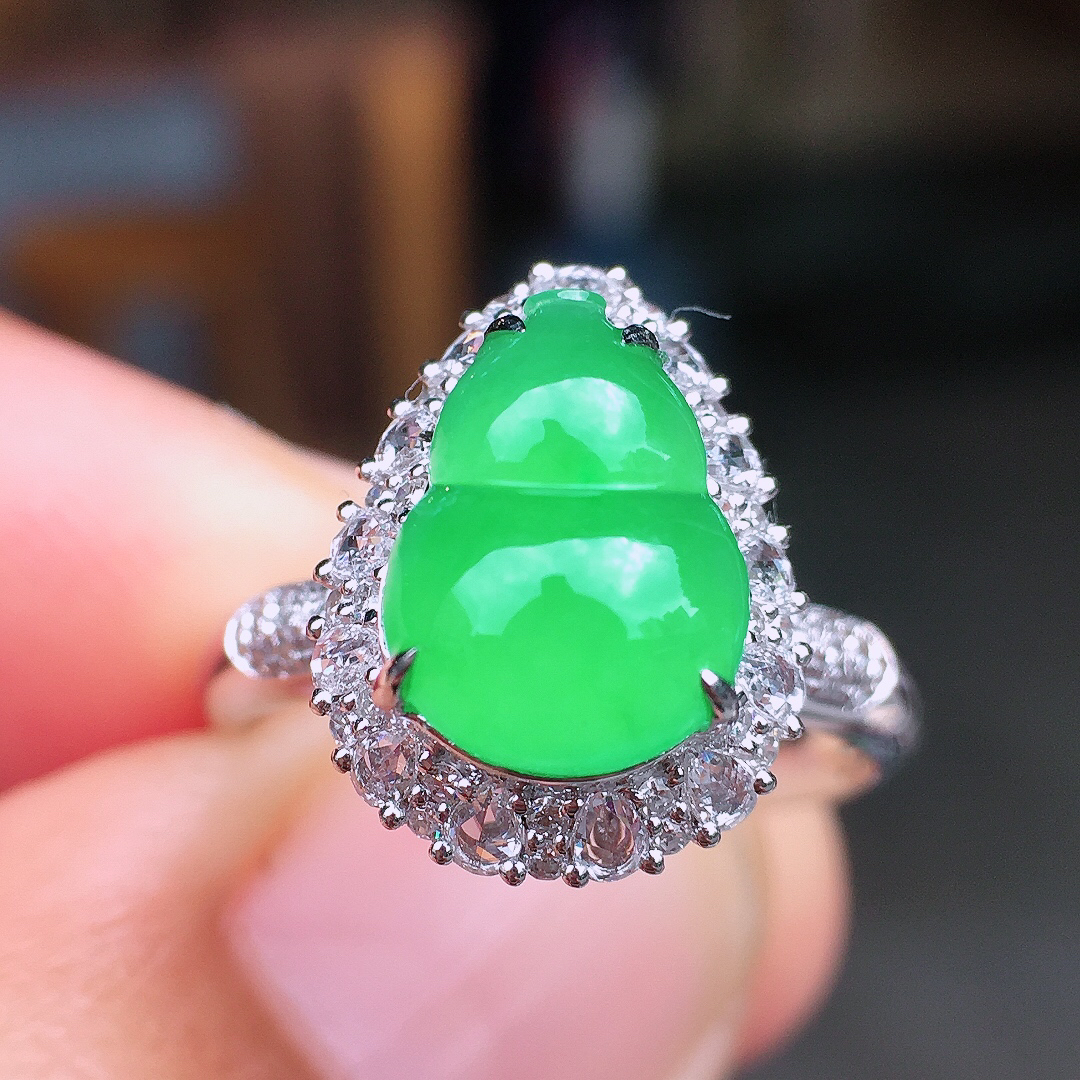 阳绿葫芦戒指，色泽均匀艳丽，玉质细腻，荧光感超
强，饱满圆润，尽显优雅气质，18k
金豪华镶嵌