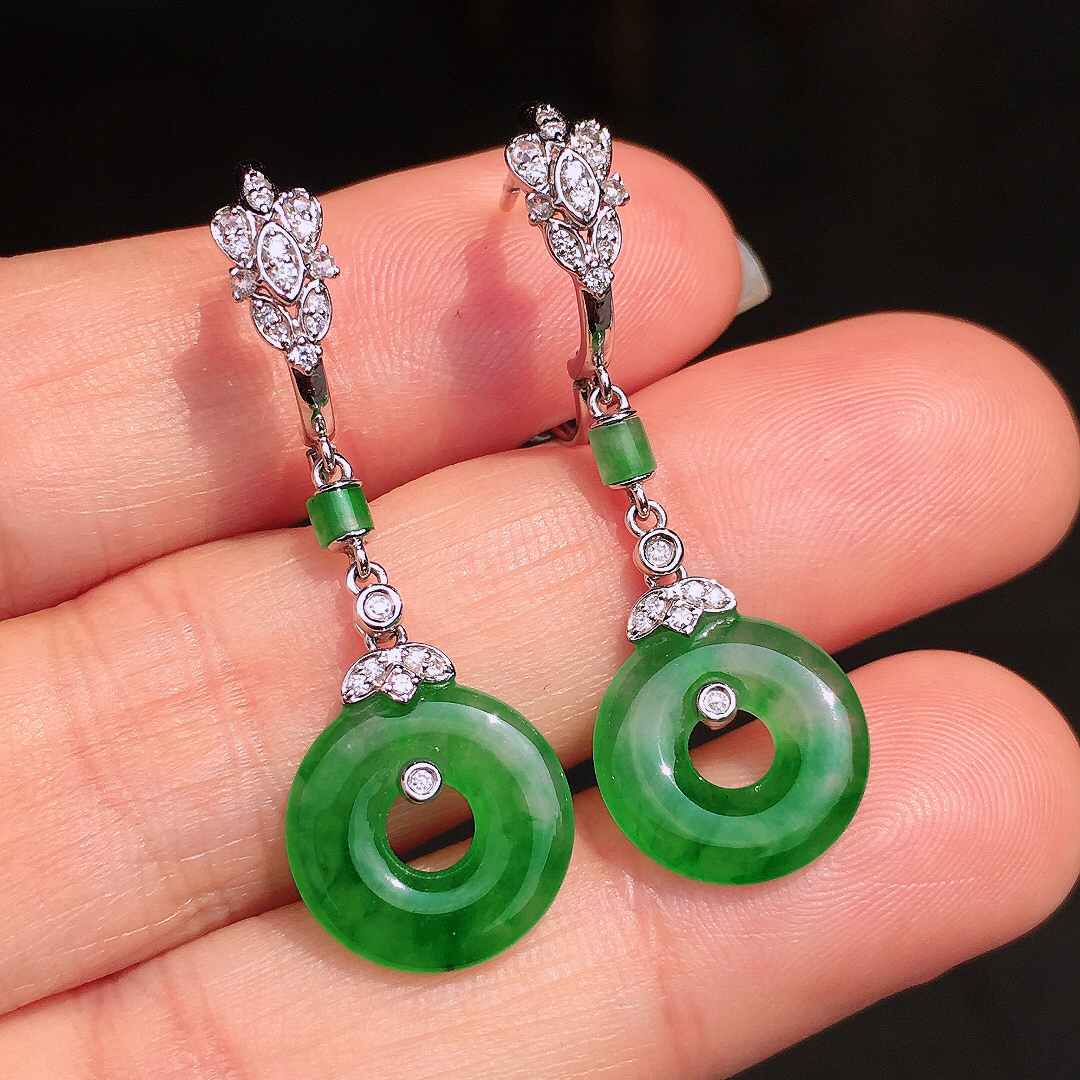 阳绿平安扣耳坠，色泽均匀艳丽，玉质细腻，荧光感超
强，饱满圆润，尽显优雅气质，18k
金豪华镶嵌