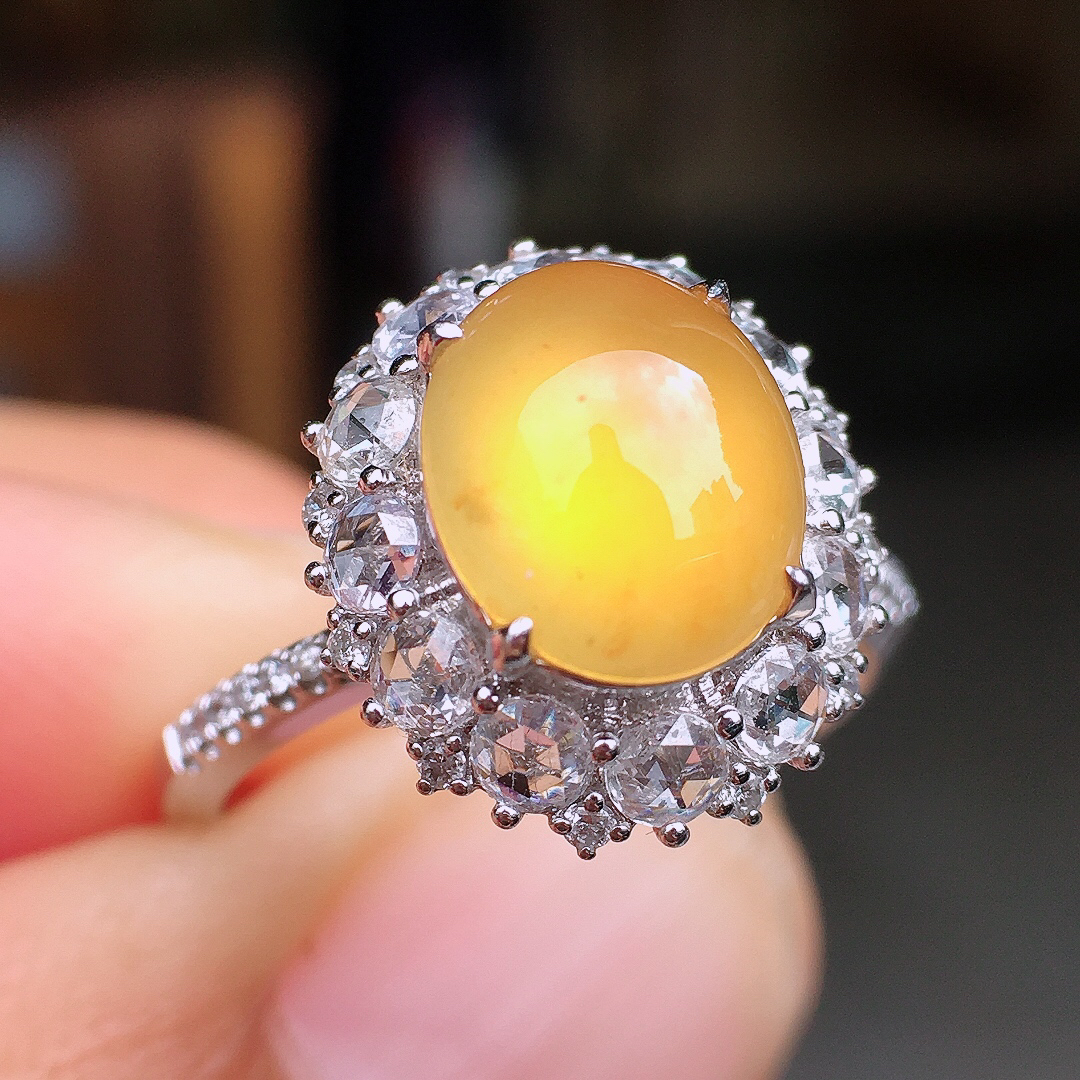 黄翡蛋面戒指，色泽均匀艳丽，玉质细腻，荧光感超
强，饱满圆润，尽显优雅气质，18k
金豪华镶嵌