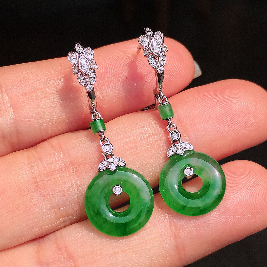 阳绿平安扣耳坠，色泽均匀艳丽，玉质细腻，荧光感超
强，饱满圆润，尽显优雅气质，18k
金豪华镶嵌