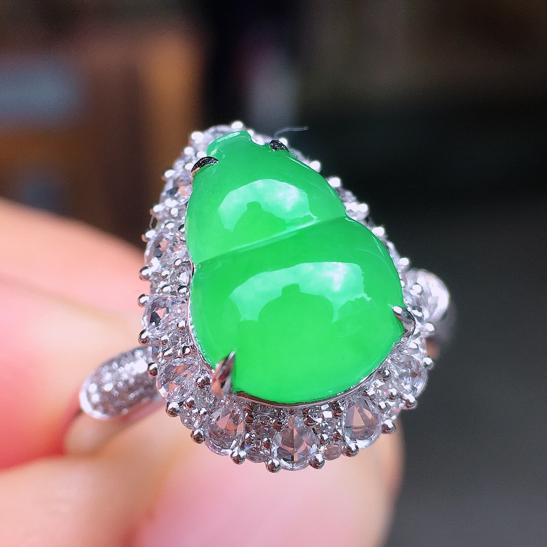 阳绿葫芦戒指，色泽均匀艳丽，玉质细腻，荧光感超
强，饱满圆润，尽显优雅气质，18k
金豪华镶嵌