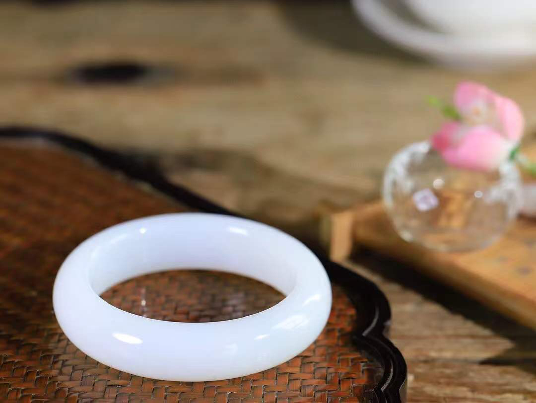 （一见倾心.手镯）

精品和田玉白玉手镯，玉质温润细腻 油性十足 手感舒适，高华雅逸，线条流畅，简约大气，美自天成，素雅高贵。佩戴于腕间，婉约之美，举手投足间透出那低调奢华。重69.7克  尺寸53-15.3-9.6mm  56372436A